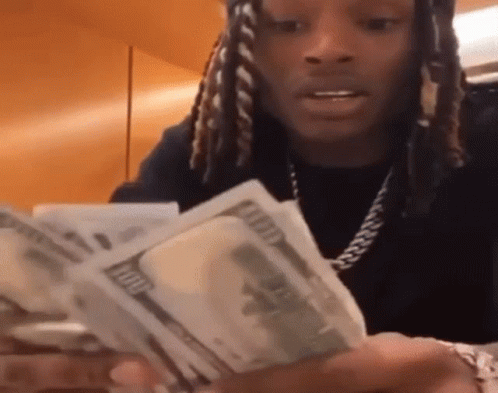 A Man With Dreadlocks Is Holding A Bunch Of Money . GIF