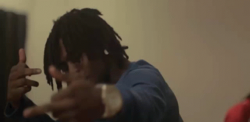 a man with dreadlocks is making a peace sign with his hands
