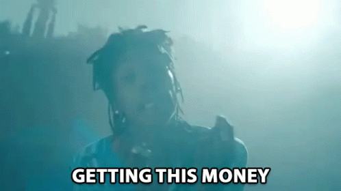 A Man With Dreadlocks Is Singing Into A Microphone With The Words Getting This Money Above Him GIF
