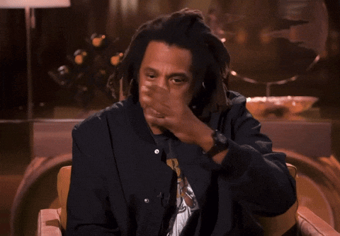 A Man With Dreadlocks Is Sitting In A Chair Giving A Thumbs Up GIF