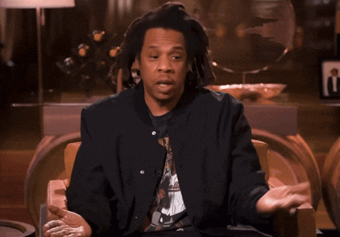 A Man With Dreadlocks Is Sitting In A Chair Talking GIF