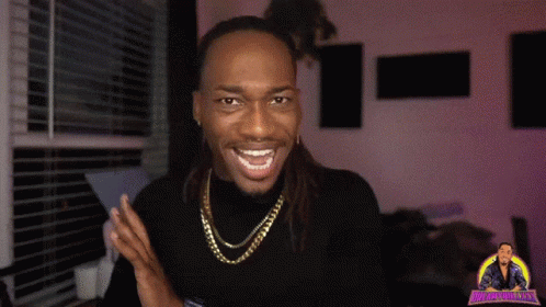 A Man With Dreadlocks Is Smiling And Wearing A Gold Chain Around His Neck .. GIF