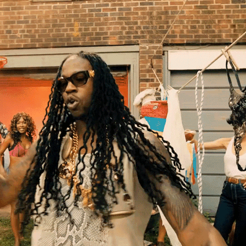 A Man With Dreadlocks Is Standing In Front Of A Clothes Line GIF