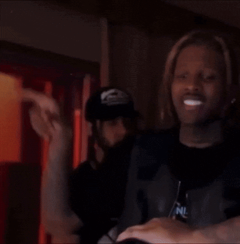 A Man With Dreadlocks Is Standing Next To A Woman In A Dark Room . GIF