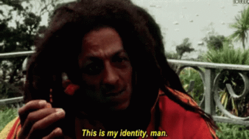 A Man With Dreadlocks Is Talking On A Cell Phone And Says " This Is My Identity Man " GIF
