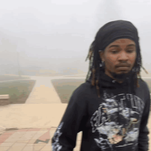 A Man With Dreadlocks Is Wearing A Black Shirt That Says ' Faith ' GIF