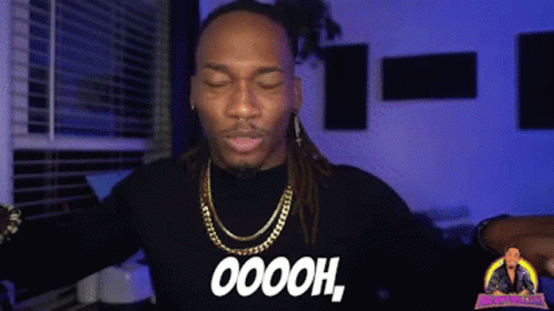 A Man With Dreadlocks Is Wearing A Black Shirt That Says Oooh GIF