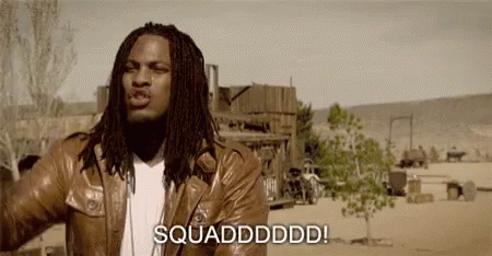 A Man With Dreadlocks Is Wearing A Brown Leather Jacket And Standing In The Desert . GIF