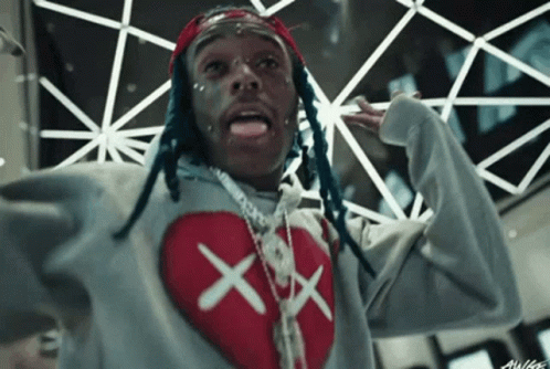 A Man With Dreadlocks Is Wearing A Grey Sweater With A Red Heart On It GIF