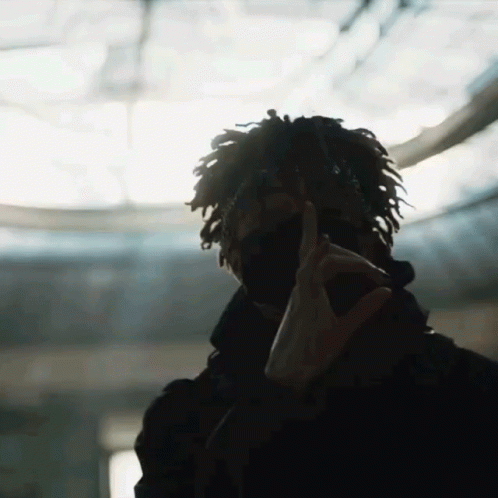 A Man With Dreadlocks Is Wearing A Mask And Making A Peace Sign With His Hands GIF