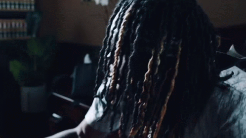 A Man With Dreadlocks Is Wearing A Shirt That Says Dior On It GIF