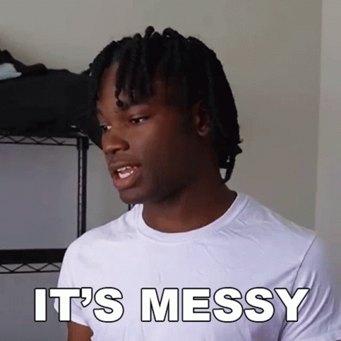 A Man With Dreadlocks Is Wearing A White T-Shirt That Says It 'S Messy GIF