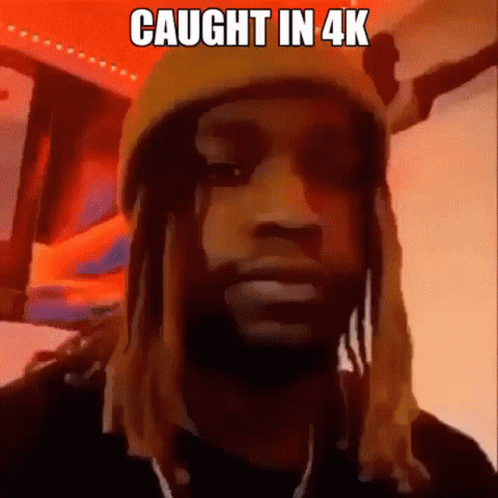 A Man With Dreadlocks Is Wearing A Yellow Hat And Looking At The Camera With The Caption `` Caught In 4K '' . GIF
