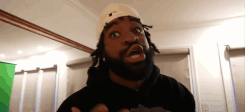 A Man With Dreadlocks Wearing A Hat That Says Ny GIF