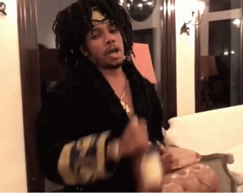A Man With Dreadlocks Wearing A Headband And A Black Robe GIF