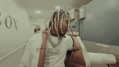 A Man With Dreadlocks Wearing A Shirt That Says Neo GIF