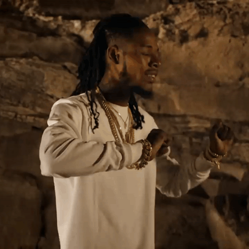 A Man With Dreadlocks Wearing A White Sweater And Gold Chains GIF