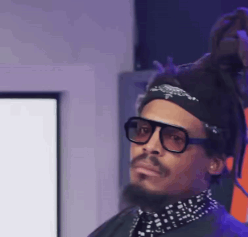 A Man With Dreadlocks Wearing Sunglasses And A Bandana GIF