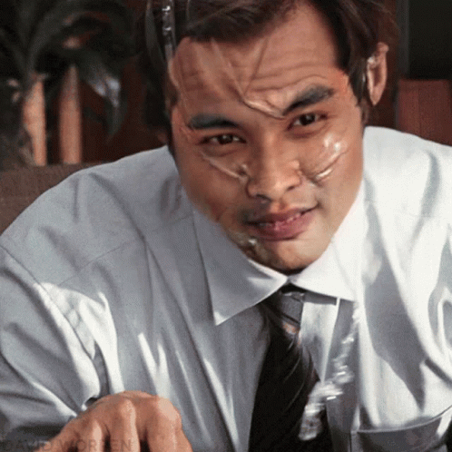 A Man With Duct Tape On His Face Is Sitting At A Desk GIF