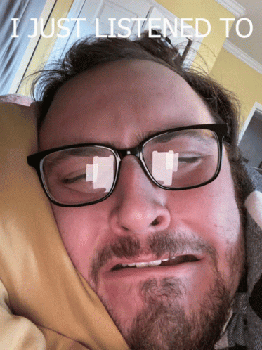 A Man With Glasses And A Beard Is Laying In Bed With The Words I Just Listened To Written Above Him GIF