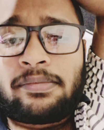 a man with glasses and a beard is looking at the camera
