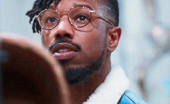 A Man With Glasses And A Beard Is Looking Up At Something . GIF