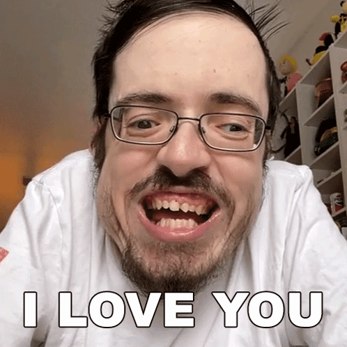 A Man With Glasses And A Beard Is Making A Funny Face And Says I Love You GIF