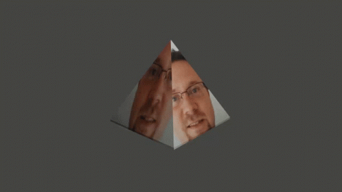 A Man With Glasses And A Beard Is Reflected In A Glass Pyramid GIF