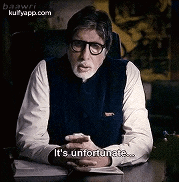 A Man With Glasses And A Beard Is Sitting At A Desk And Talking . GIF