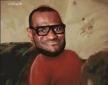 A Man With Glasses And A Beard Is Smiling For The Camera . GIF