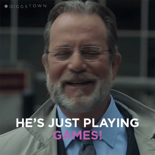 A Man With Glasses And A Beard Is Smiling With The Words He 'S Just Playing Games Below Him GIF