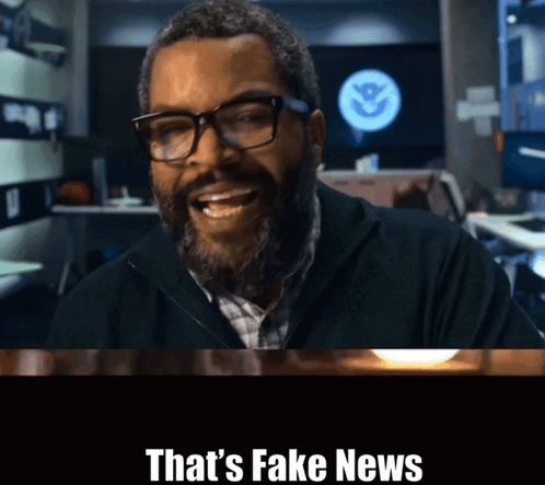 A Man With Glasses And A Beard Is Smiling With The Words That 'S Fake News Above Him GIF