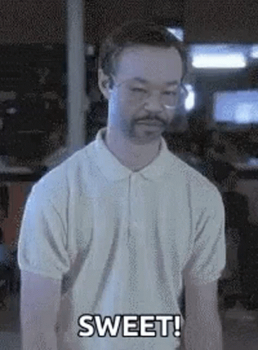 A Man With Glasses And A Beard Is Standing In A Room And Saying Sweet . GIF