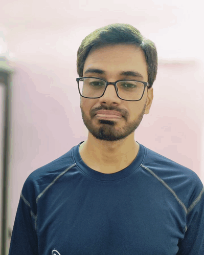 A Man With Glasses And A Beard Is Wearing A Blue Shirt With The Letter G On It GIF