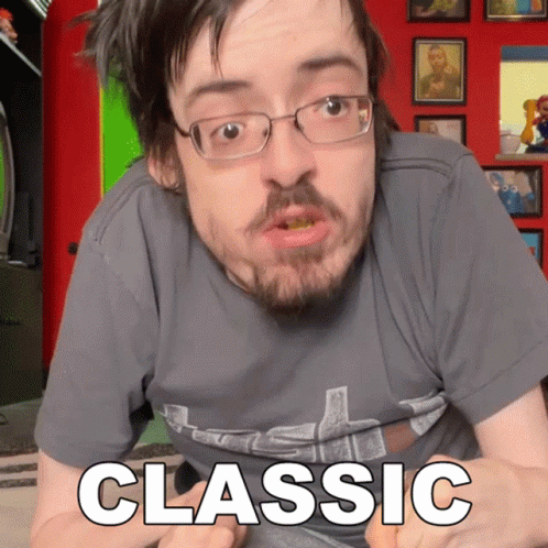 A Man With Glasses And A Beard Is Wearing A Grey Shirt That Says Classic GIF