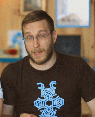 A Man With Glasses And A Beard Is Wearing A T-Shirt With A Blue Design GIF