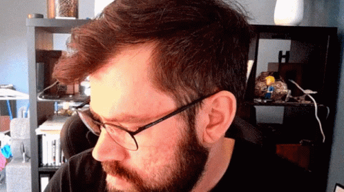 A Man With Glasses And A Beard Looks At The Camera GIF