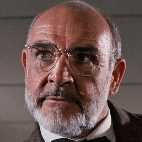 A Man With Glasses And A Beard Looks To His Left GIF