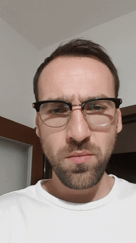 A Man With Glasses And A Beard Makes A Face GIF