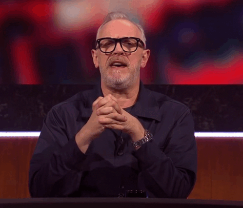 A Man With Glasses And A Beard Making A Devil Horns Gesture GIF