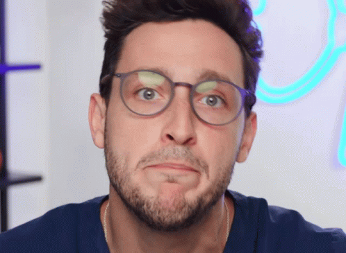 A Man With Glasses And A Beard Making A Face GIF