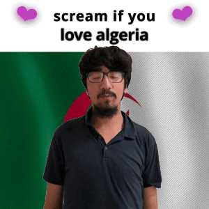 A Man With Glasses And A Beard Stands In Front Of An Algeria Flag And Says Scream If You Love Algeria GIF