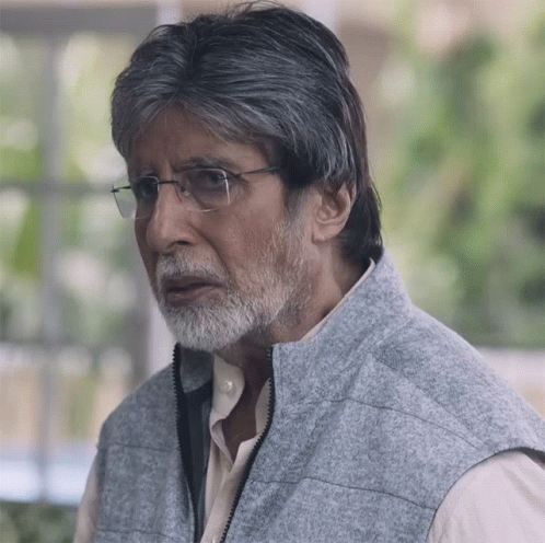 A Man With Glasses And A Beard Wears A Gray Vest GIF