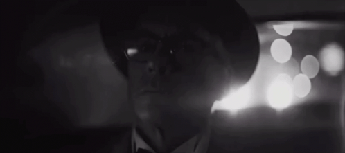 A Man With Glasses And A Hat Is Looking At The Camera GIF