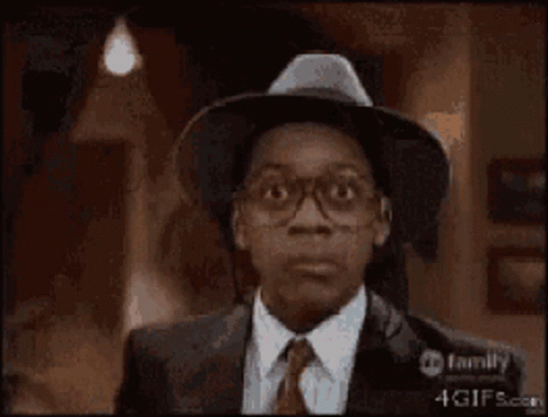 A Man With Glasses And A Hat Is Smiling GIF