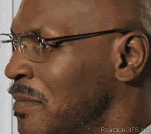 A Man With Glasses And A Mustache Is Making A Face . GIF