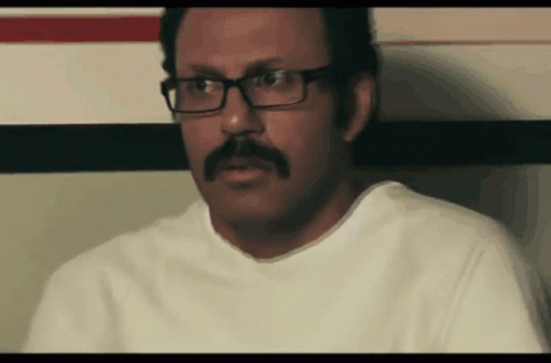 Man With Glasses And Mustache Sitting Down GIF