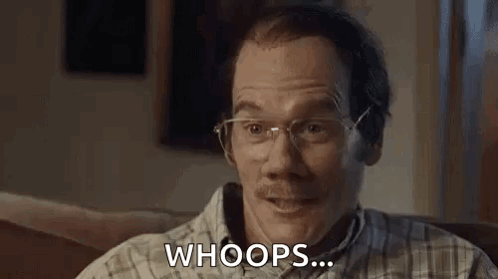 A Man With Glasses And A Mustache Is Sitting On A Couch And Making A Funny Face . GIF