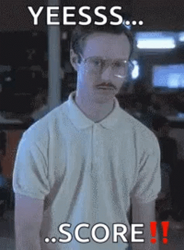 A Man With Glasses And A Mustache Is Standing In Front Of A Sign That Says Yeesss Score GIF