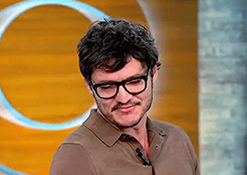 A Man With Glasses And A Mustache Is Standing In Front Of A Wooden Wall With A Circle In The Background . GIF